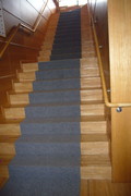 踊り場と手すりのある階段の写真。滑り止めにカーペットが敷かれ安心です