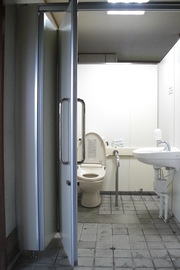 第１駐車場公衆トイレの写真。第１駐車場にある車いすマークトイレの中です。折れ戸になっています。