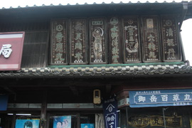 江戸時代から続く老舗の水野薬局の写真。町家様式の建物の軒下には、木製の歴史ある看板が並んでいます。