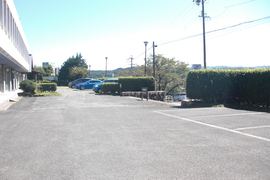 施設建物前の駐車場（舗装）の写真。路面は舗装されています