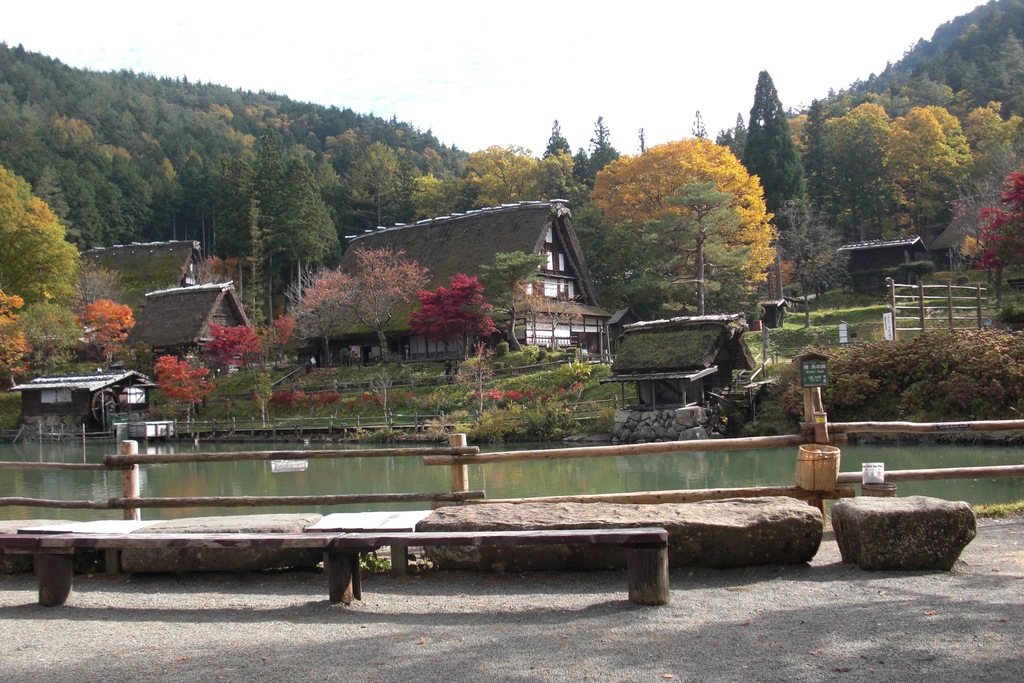 紅葉の中の五阿弥池と合掌造りの写真