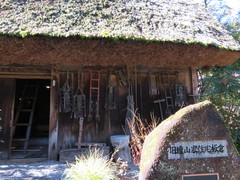 旧遠山家住宅板倉の写真。茅葺屋根の建物は国登録有形文化財となっています