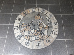 トイレの床の方位盤（１）の写真。古川の祭り「起こし太鼓」に十二支が書かれた不思議な図