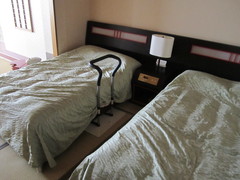 ユニバーサルルーム和室の寝室の写真。畳の上にベッドが置かれ手すりも設置されています