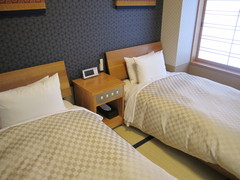 ユニバーサルルーム和室の寝室の写真。畳の上にベッドが置かれています