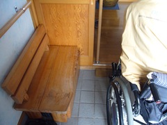 玄関の手すりとベンチの写真。足の不自由な方やお年寄りのために、履物の脱ぎ履きがしやすいようベンチと手すりが設置されています。