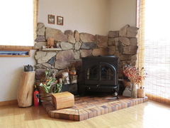 食堂の片隅に薪ストーブの写真。薪ストーブで高山の冬も暖めてくれます。