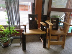 木工作品の写真。入口にユニークなデザインの天然木の椅子が置かれていました