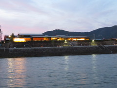 川岸に見える長良川うかいミュージアムの写真。薄暮の中、対岸にうかいミュージアムの灯りが見えます。