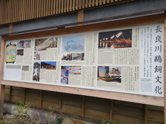 長良川鵜飼の説明看板の写真。待合所の外壁に掲げられた看板には写真付きの説明が書かれています。