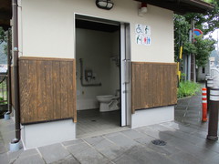 公衆トイレ外観の写真。入口は間口が広く引き戸、建物前は平坦になっています。
