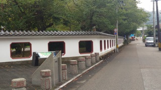 庭園を囲む白壁の塀の写真。瓦葺きで白壁に朱色の窓枠がある立派な塀が中国を感じさせます。