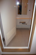 バリアフリールームのお風呂の写真。入口に１段段差があり、開き戸です。