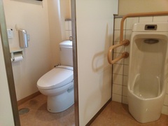 2階のトイレの写真。洋式トイレは便座の横にドアがあります。男性用便器には手すりもあります