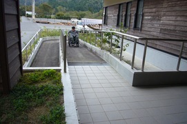 学習館前のスロープの写真。正面は階段ですが、横に幅の広い手すり付きのスロープがあります