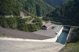 ロックフィルダムと400m下の水力発電施設の写真。堤頂からダムの底をを眺めると、徳山ダムの高さ、大きさにはとても驚きます