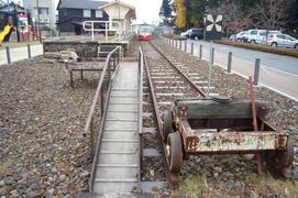 線路の端から見た赤白電車の写真。線路は当時のままで、ホームには手作りの赤白電車が停車しています