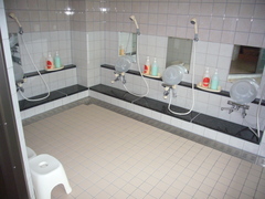 大浴場の写真。洗い場が６つあり、浴槽は低く手すりがついています