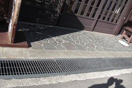 店舗入口の写真。段差はありませんが、グレーチングがあり車いすのキャスターに注意