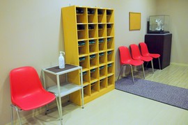 工場内はスリッパに履き替えの写真。車いす以外の方は、見学前にスリッパに履き替えます。椅子も準備され安心です。