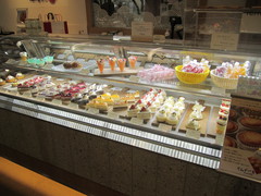 ケーキショーケースの写真。さまざまなケーキやシュークリーム、ゼリーなどがキレイに並べられています