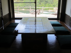 囲炉裏のある座敷席の写真。古民家風の座敷からはガラス越しに長良川が見られます