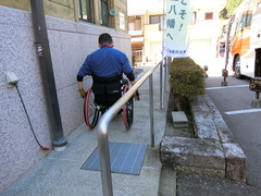 車いすは横のスロープから（２）の写真。緩やかなスロープを建物に沿って進む