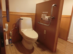 車いす対応室のトイレの写真。手すりが設置され段差はありません