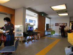 正面入口（資料館側から）の写真。自動ドアの横には中津川宿の映像が流れています。