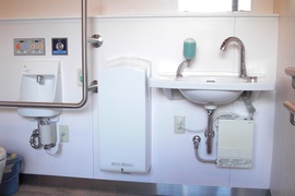 多目的トイレの写真。自動で水が出る手洗い、乾燥機、壁にも手すりがあり快適ですね。