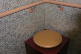 エレベーター内の腰掛の写真。エレベーター内に手すりや、休憩用の腰掛が設置されています