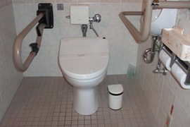 バリアフリー対応客室のトイレの写真。車いすで利用しやすくなっており、手すりや温水洗浄便座などもついています