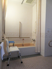 バリアフリー対応客室のお風呂の写真。手すりが付き、シャワーチェアやバスタブ椅子も使えます