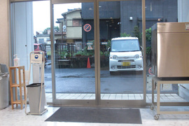 裏口の自動ドアの写真。駐車場から建物までは裏口からが近くて便利です