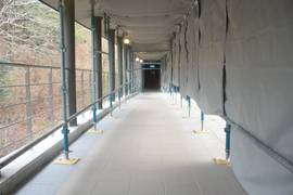 駐車場から建物への長い通路の写真。途中に傾斜もあります（写真は工事中です）