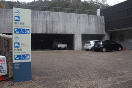 建物のすぐそばにある搬入車両駐車場の写真。車いすマーク駐車スペースもあります