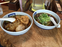 高山ラーメンの写真。醤油ベースのスープ、葱・叉焼のシンプルな具と細いちぢれ麺が特徴。