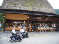 茅葺屋根のお土産店の写真。和田家の隣にあるお店。木挽きのしげじいさんが店先で待っています。