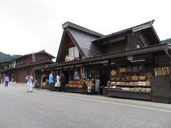 大通りに面したおみやげ店の写真。木堀り、すかしふくろうなどの民芸品や白川郷せんべいなども並んでいます。
