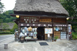 せせらぎ公園内のおみやげ店の写真。茅葺き屋根の小さなお土産屋です。飛騨の地酒や白川郷クッキーが人気です。