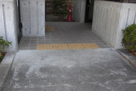トイレ入り口の写真。舗装され傾斜もなく、点字ブロックが敷かれています