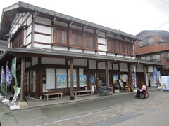 伝統的な飛騨の建築様式の写真。豪雪地帯の家屋を支える太い柱が使われ、軒の深い白壁のがっしりした建築物です