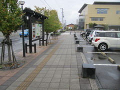 図書館前の道路の写真。歩道は広く点字ブロックも設置されています