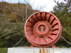 駐車場にある水車の写真。御母衣ダムで発電に使われていた直径4メートルの水車